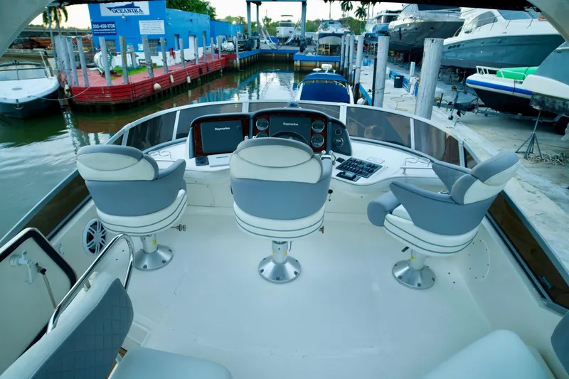 Slide: The Image of 2006 Sea Ray 44 Sedan Bridge helm with three seats, docked at marina. - 7