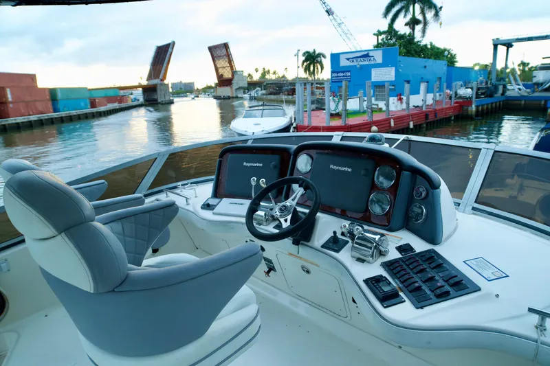 Slide: The Image of 2006 Sea Ray 44 Sedan Bridge helm with dual Raymarine displays, dockside view. - 8