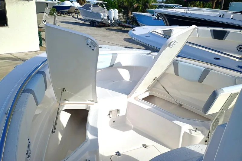 Slide: The Image of 2025 Robalo R230 Center Console boat with open storage compartments on deck. - 11