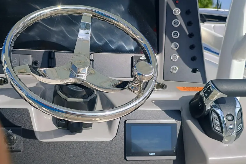 Slide: The Image of Steering wheel and controls of 2025 Robalo R230 Center Console boat. - 13