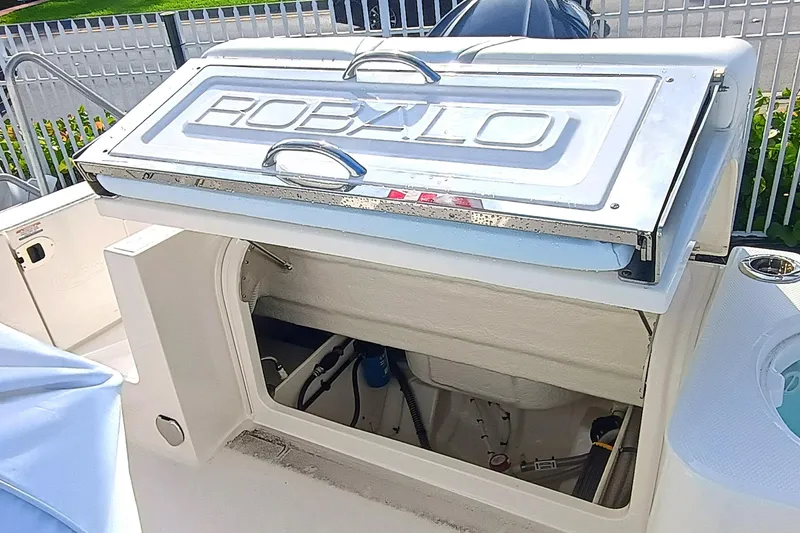 Slide: The Image of 2025 Robalo R230 Center Console boat storage compartment with open hatch. - 19