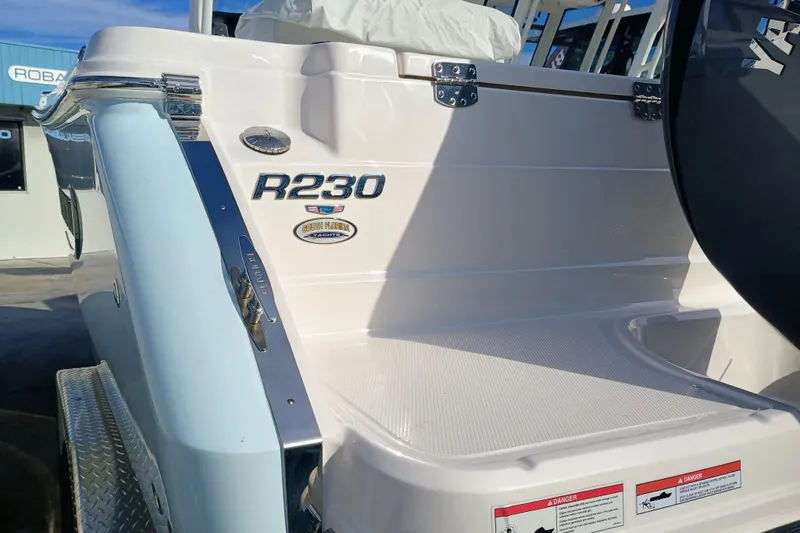 Slide: The Image of 2025 Robalo R230 Center Console boat, rear view with branding and details. - 22