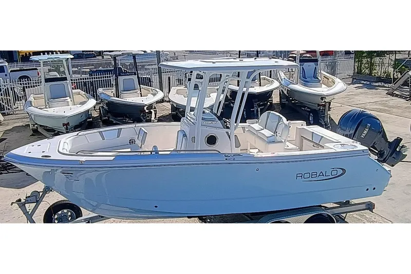 Slide: The Image of 2025 Robalo R230 Center Console boat displayed on a trailer in a marina. - 4