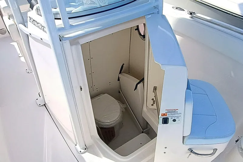 Slide: The Image of 2025 Robalo R230 Center Console boat interior with compact marine toilet. - 9