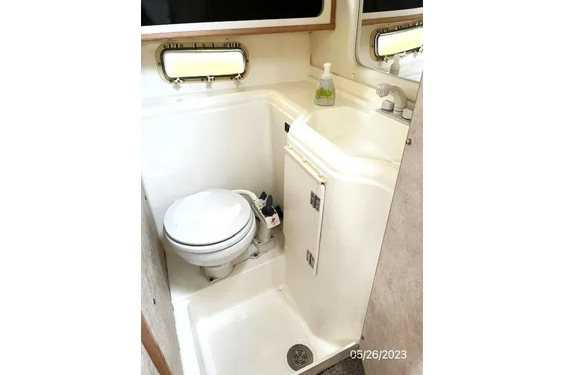 Slide: The Image of 1997 Bayliner 2855 Ciera boat bathroom with toilet, sink, and window. - 4