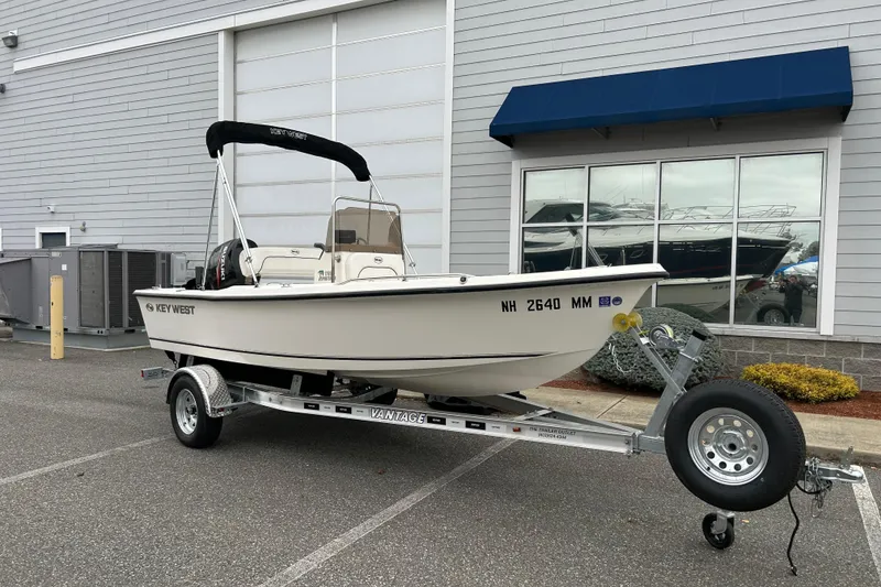 The Image of 2014 Key West 1720 Center Console boat on trailer, parked outside a building. - 1