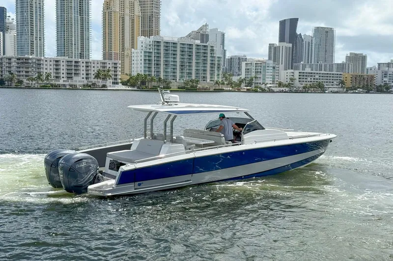 Slide: The Image of 2024 Opus OPUS 12 boat cruising near city skyline, featuring dual outboard engines. - 3