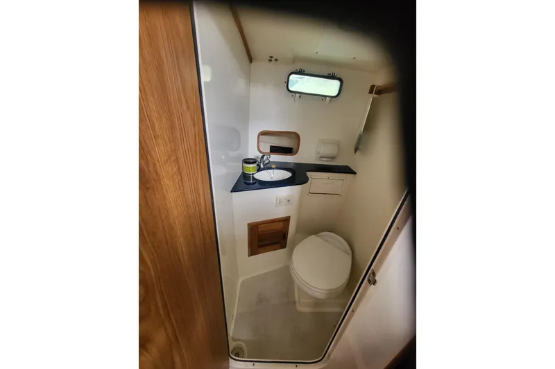 Slide: The Image of 2014 Eastern Islander 270 boat bathroom with sink, toilet, and window. - 5