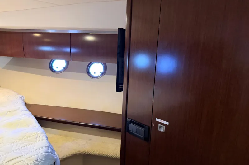 Slide: The Image of 2011 Cruisers Yachts 540 Sports Coupe interior with wood paneling and porthole windows. - 44