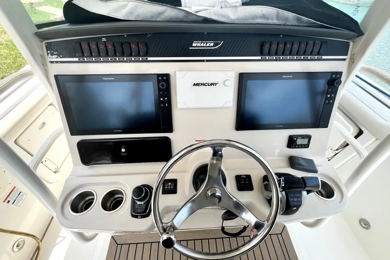 Slide: The Image of 2019 Boston Whaler 330 Outrage helm with dual Raymarine displays and Mercury controls. - 4