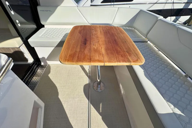 Slide: The Image of 2021 Regal 38 Grande Coupe interior with quilted seating and wooden table. - 12