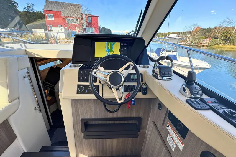 Slide: The Image of 2021 Regal 38 Grande Coupe helm with navigation display and controls. - 28