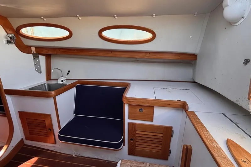 Slide: The Image of Interior of 2016 Alerion Express 28 sailboat with wooden trim and compact seating area. - 29