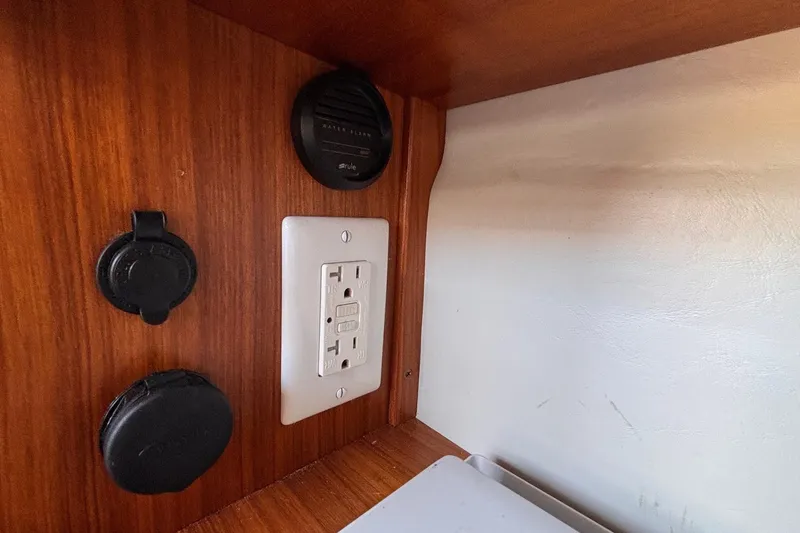 Slide: The Image of Electrical outlet and controls inside a 2016 Alerion Express 28 sailboat cabin. - 32