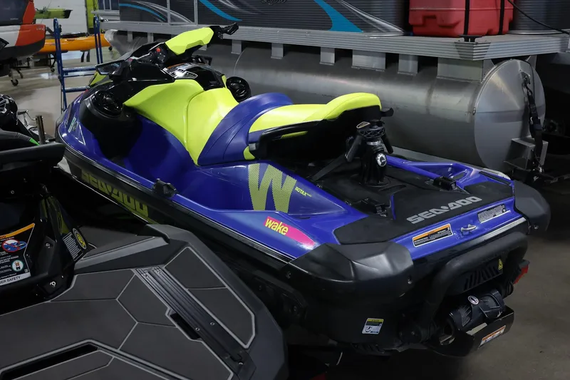 Slide: The Image of 2020 Sea Doo 170 jet ski in vibrant blue and yellow, parked indoors. - 6