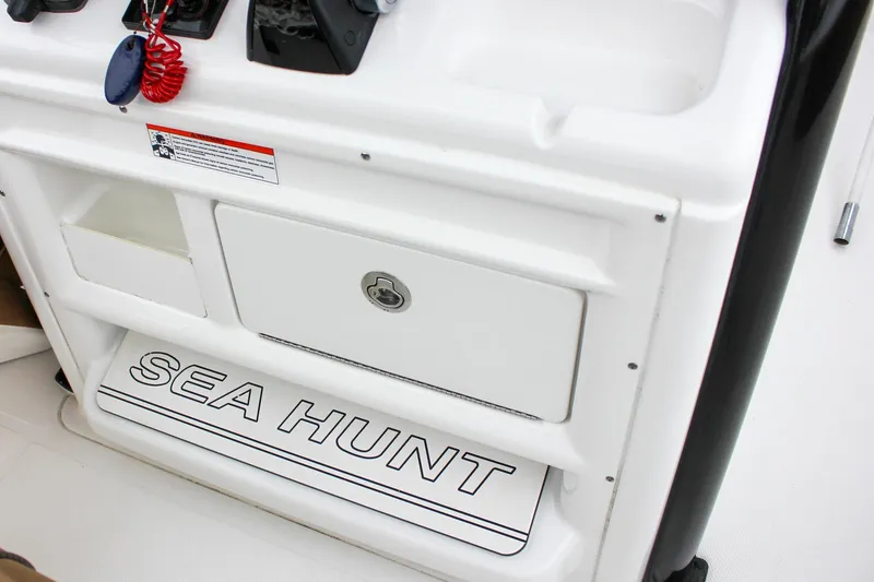 Slide: The Image of 2020 Sea Hunt Ultra 275 SE boat console with storage compartment and branding. - 30