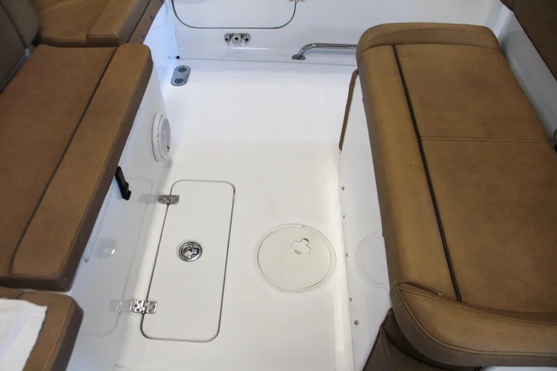 Slide: The Image of 2020 Sea Hunt Ultra 275 SE boat interior with brown cushioned seating and storage compartments. - 48