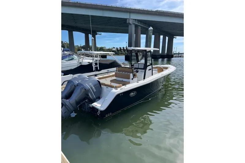 Slide: The Image of 2020 Sea Hunt Ultra 275 SE boat docked under a bridge with Yamaha engines. - 5