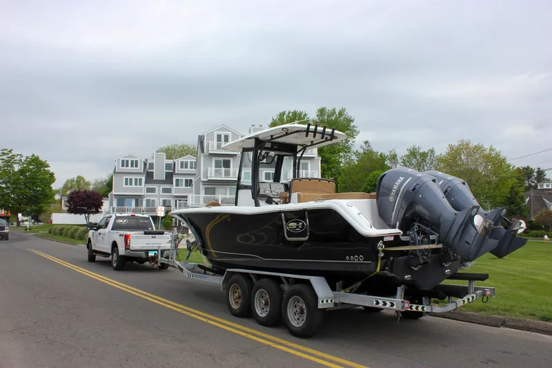 Slide: The Image of 2020 Sea Hunt Ultra 275 SE boat on trailer, towed by a white truck near residential area. - 53