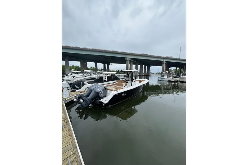 Slide: The Image of 2020 Sea Hunt Ultra 275 SE boat docked near a bridge on a cloudy day. - 54