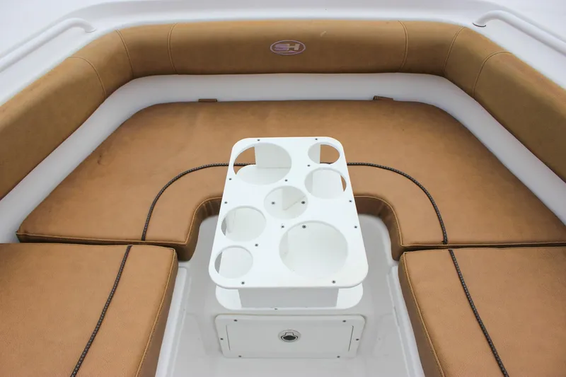 Slide: The Image of 2020 Sea Hunt Ultra 275 SE boat interior with tan seating and cup holder table. - 6