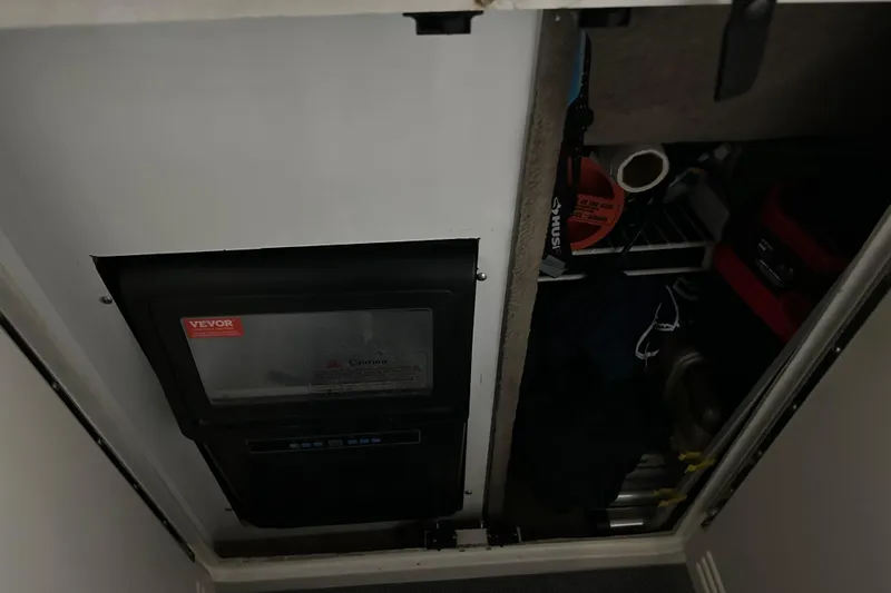 Slide: The Image of Storage compartment in a 1997 Sea Ray 400 Sundancer boat, featuring various tools and equipment. - 26