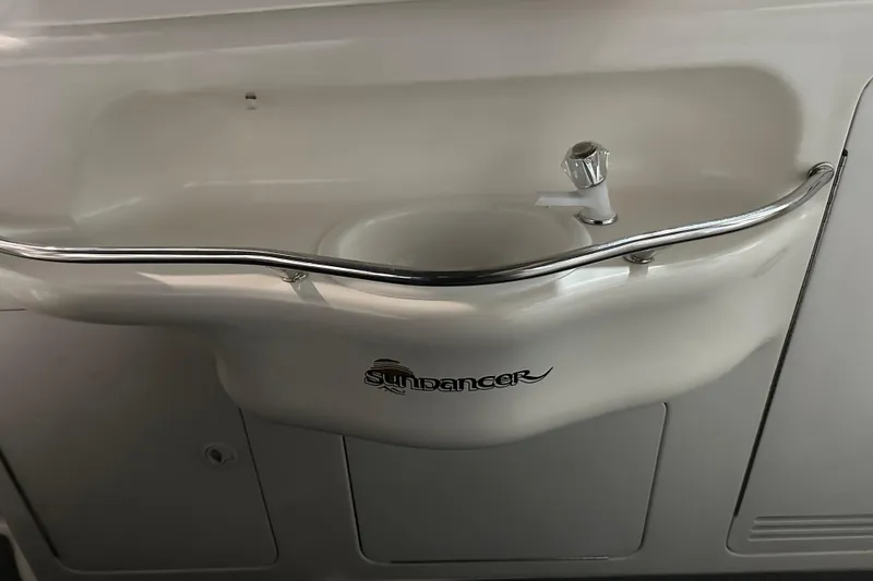 Slide: The Image of 1997 Sea Ray 400 Sundancer boat sink with chrome rail and faucet. - 28