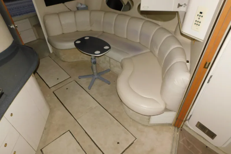 Slide: The Image of Interior of 1997 Sea Ray 400 Sundancer with curved seating and small table. - 32