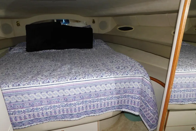 Slide: The Image of Cozy cabin interior of 1997 Sea Ray 400 Sundancer with patterned bedding. - 35