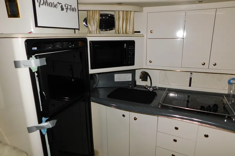 Slide: The Image of 1997 Sea Ray 400 Sundancer yacht kitchen with microwave, fridge, and stove. - 43