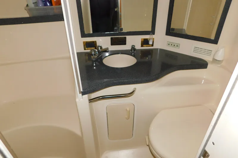 Slide: The Image of 1997 Sea Ray 400 Sundancer bathroom with sink, mirror, and toilet. - 46