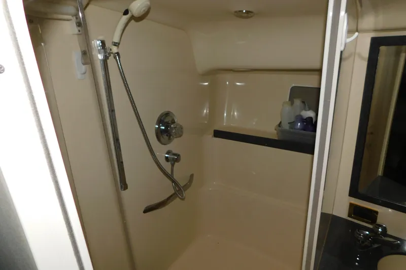 Slide: The Image of Shower area in 1997 Sea Ray 400 Sundancer yacht, featuring beige interior and chrome fixtures. - 47