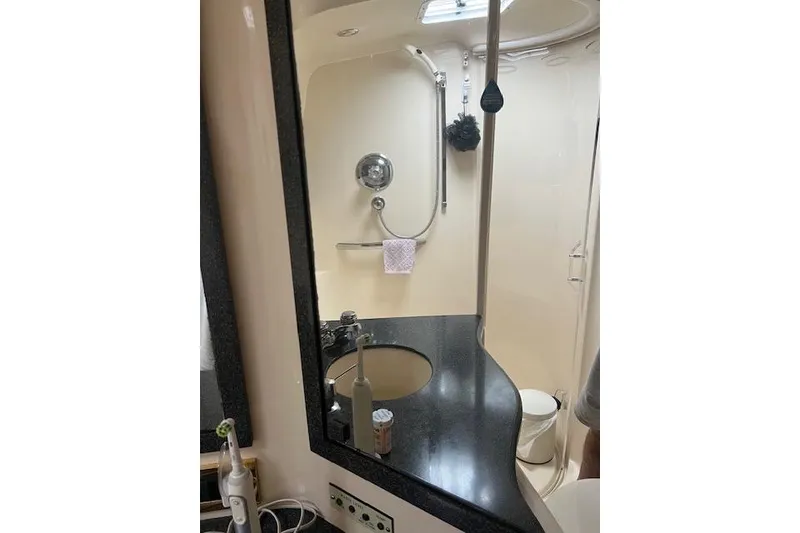 Slide: The Image of Bathroom interior of 1997 Sea Ray 400 Sundancer yacht, featuring sink and shower area. - 49