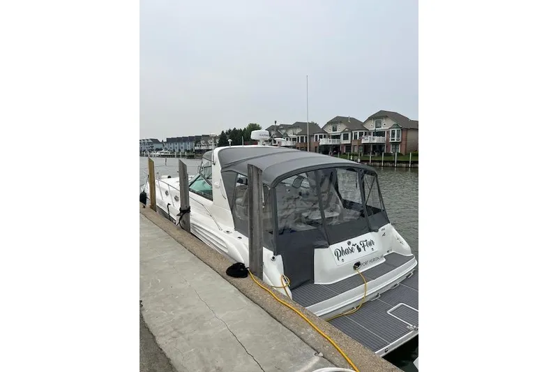 Slide: The Image of 1997 Sea Ray 400 Sundancer docked by waterfront homes. - 5