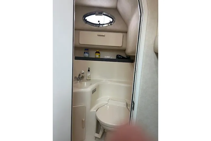 Slide: The Image of 1997 Sea Ray 400 Sundancer bathroom with sink, toilet, and storage cabinet. - 54