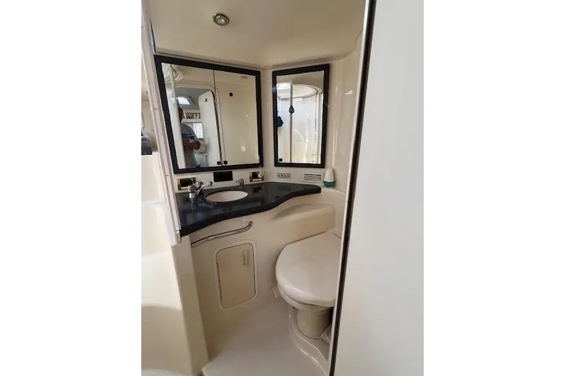 Slide: The Image of 1997 Sea Ray 400 Sundancer bathroom with sink, mirror, and toilet. - 56