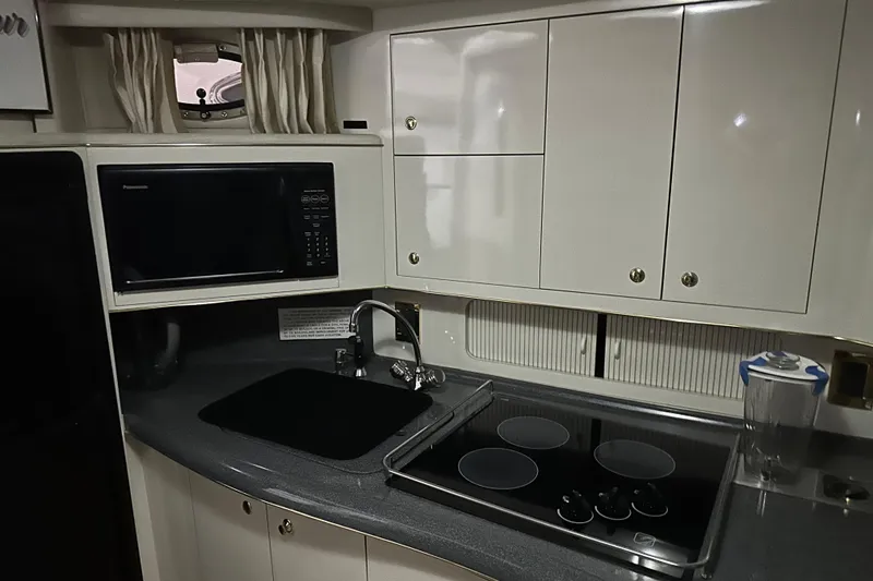 Slide: The Image of 1997 Sea Ray 400 Sundancer yacht kitchen with microwave, stove, and sink. - 59
