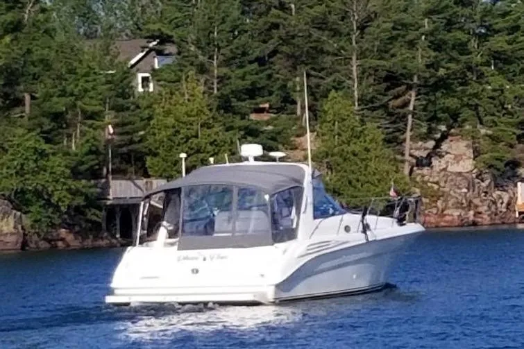 Slide: The Image of 1997 Sea Ray 400 Sundancer cruising on a lake with forested shoreline. - 6