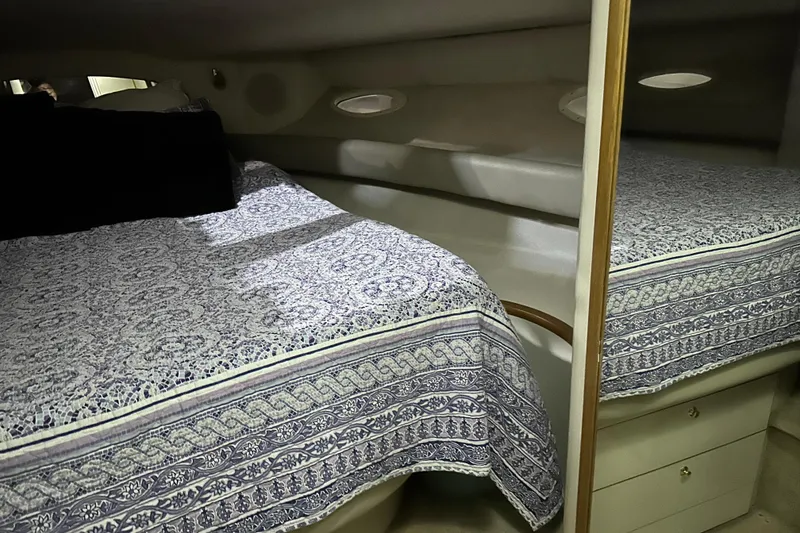Slide: The Image of Interior cabin of 1997 Sea Ray 400 Sundancer with patterned bedding and storage drawers. - 69