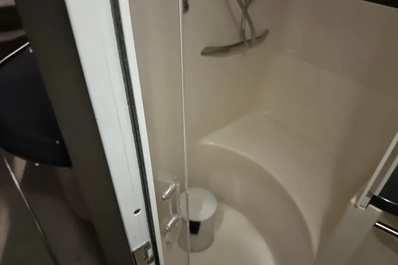 Slide: The Image of Shower area inside 1997 Sea Ray 400 Sundancer yacht, featuring a curved seat and fixtures. - 75