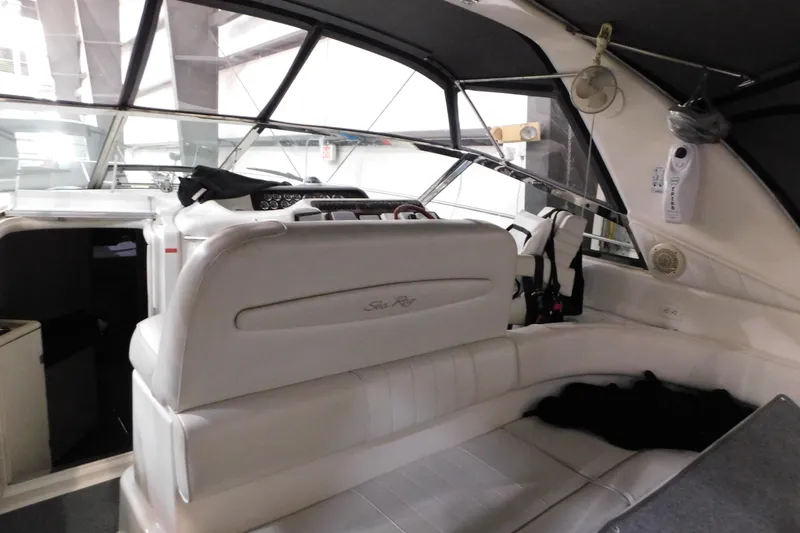 Slide: The Image of Interior of a 1997 Sea Ray 400 Sundancer yacht with white seating and helm. - 8