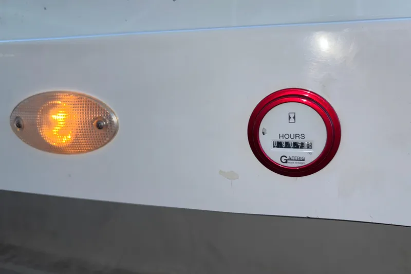 Slide: The Image of 2001 Baja 33 Outlaw hour meter and light indicator on white surface. - 12