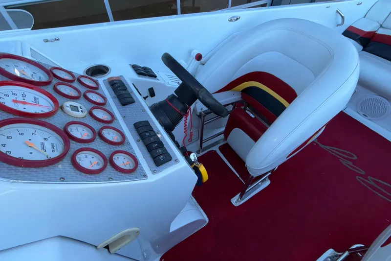 Slide: The Image of 2001 Baja 33 Outlaw boat cockpit with gauges, steering wheel, and red carpet. - 14