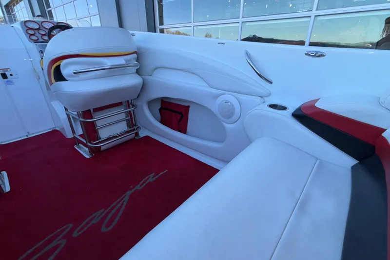 Slide: The Image of 2001 Baja 33 Outlaw boat interior with white and red seating, red carpet, and dashboard. - 19