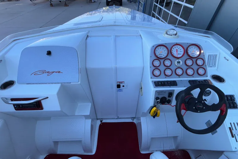 Slide: The Image of 2001 Baja 33 Outlaw boat dashboard with gauges and steering wheel. - 20