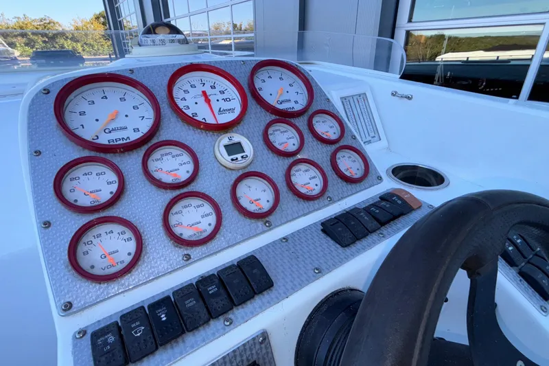 Slide: The Image of Dashboard of a 2001 Baja 33 Outlaw boat with gauges and controls. - 25
