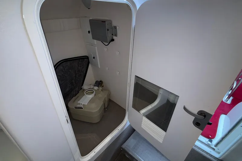 Slide: The Image of 2001 Baja 33 Outlaw boat interior with portable toilet in small compartment. - 37