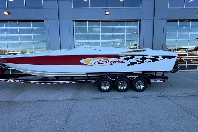 Slide: The Image of 2001 Baja 33 Outlaw speedboat on trailer, parked outside a modern building. - 39
