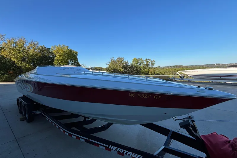 Slide: The Image of 2001 Baja 33 Outlaw boat on trailer, red and white design, parked outdoors. - 41