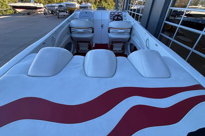 Slide: The Image of 2001 Baja 33 Outlaw boat interior with white and red seating, docked outdoors. - 6